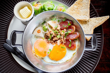 morning eggs fried with pork and bread in metal dish ready to eating
