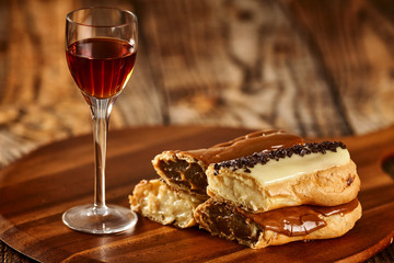 Delicious eclairs on wooden board