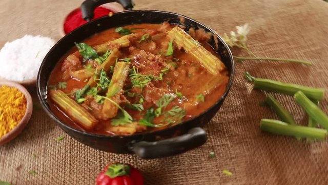 Rotating Homemade tasty Muringakka Manga Curry- Drumsticks And Mango in Coconut milk gravy served in a clay pot