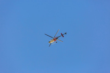 Helicopter flying high with cloudless and clear blue sky in the background