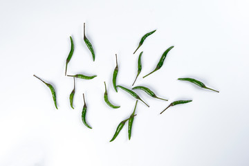 Obraz premium Fresh birds eye green chilli scattered top view on white background