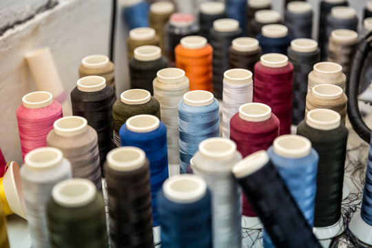 Many reels of colored threads standing