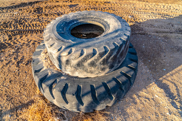 Old and dirty rubber tires stacked on top of each other viewed on a sunny day