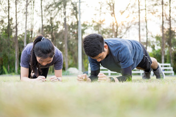 Early morning workout, Fitness couple stretching outdoors in park. Young man and woman exercising together in morning, Living healthy lifestyle fitness, sport concept.