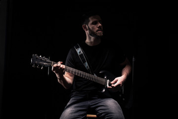 Naklejka premium one man, rock or metal musician, almost unrecognizable person, playing a guitar.