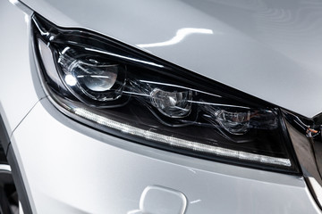 Concept of modern car detailing and light technology.  Close up of headlight on expensive car with...