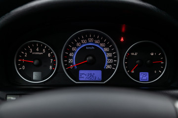 New sports car speedometer, dashboard and tachometer  with blue backlight and other buttons.