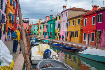 Burano island exterior with colorful residential houses, Venice, Italy. Canal with boats in Burano, Venice