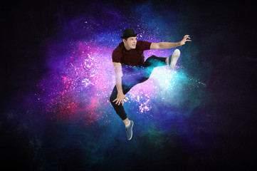 Fototapeta na wymiar Modern dancer jumping with colourful splashes background. Mixed media
