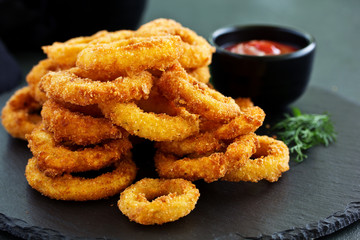 Homemade crunchy fried onion rings with tomato sauce