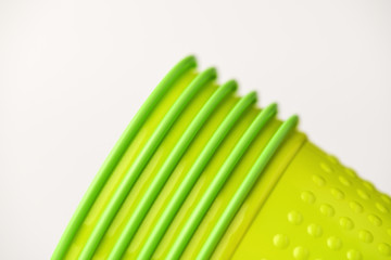 Corner of plastic cups salad, green with pimples on white background