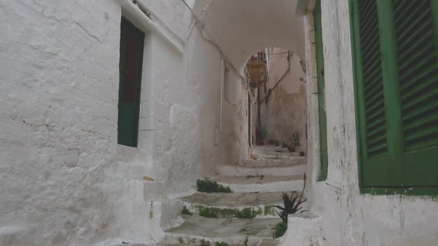 Narrow alley, whitewashed walls, staircase, medieval White Town of Ostuni, Italy