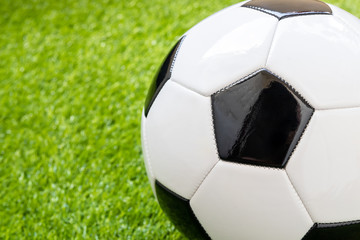 Close up of football on green artificial grass background