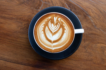 Coffee cup with latte art foam on wood table in coffee shop with copy space.Coffee is one of the most popular beverages.Improve Energy Levels and Burn Fat