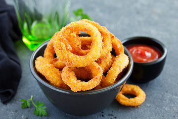 Homemade crunchy fried onion rings with tomato sauce