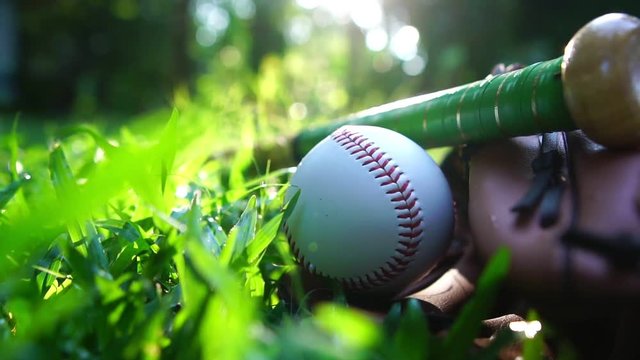 Close-up that baseball and the equipment is placed on the lawn with a warm light of sunset footage slow motion