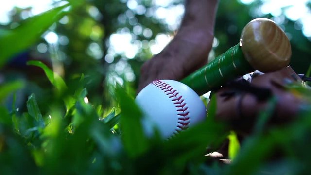 Close-up that baseball and the equipment is placed on the lawn with a warm light of sunset footage slow motion