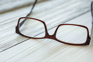 Fototapeta na wymiar A pair of eyeglasses sits on a rustic wooden surface