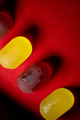 yellow and red candies on red background close up. Top view