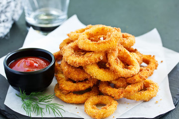Homemade crunchy fried onion rings with tomato sauce