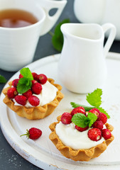 Wild strawberry tartlets with cream filling. delicious summer fruit mini tarts