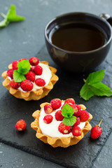 Wild strawberry tartlets with cream filling. delicious summer fruit mini tarts