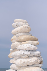 Fototapeta na wymiar stone pyramid on sky beach Zen rock in concept of balance and harmony