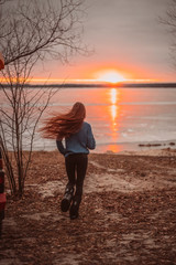 Woman enjoying time relaxing by the beautiful lake at sunrise.