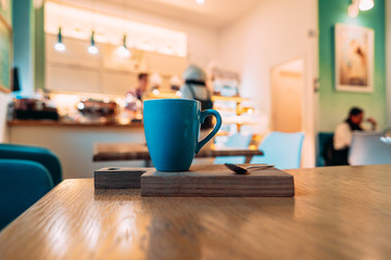Hot cappuccino coffee in coffee shop on wooden table