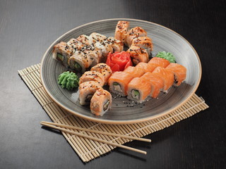 Fresh and delicious sushi set on black table