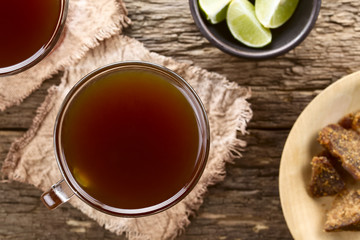 Fresh homemade Aguapanela, Agua de Panela or Aguadulce Latin American sweet drink made of panela unrefined whole cane sugar (Selective Focus, Focus on the drink)