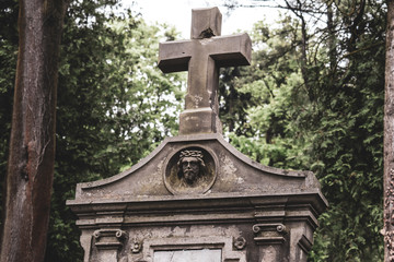 Burial vault in the cemetery, a large stone cross, the image of Jesus on the burial vault