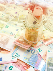 A jar of cash on the table.under jar a lot of dollars, cash, money, concept of accumulation, Finance, business, Economics