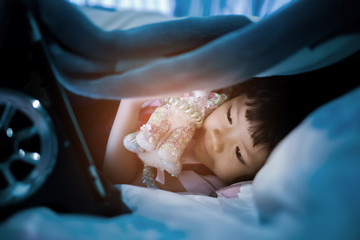 asian Chinese girl playing smartphone on bed, watching smartphone, kid use phone and play game, child use mobile, addicted game and cartoon