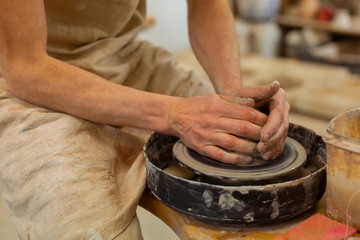 Experienced man in dirty apron having strong bare hands