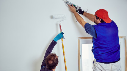 Two handymen working together on a house renovation.