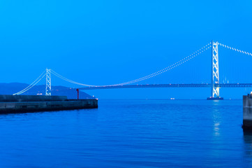 青い夕暮れとライトアップされた明石海峡の橋