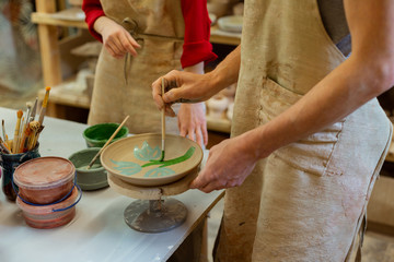 Fototapeta na wymiar Focused interested pottery master finishing production of plate