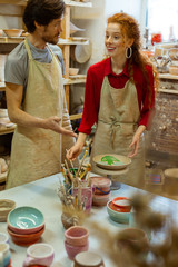 Laughing positive woman in red shirt being in great mood while working