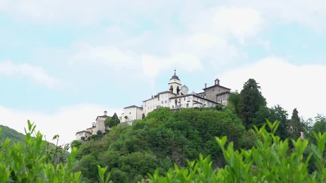 A view from the distance of the Sacred Mountain of Varallo, a christian devotional complex, a unesco world heritage si in Italy. Zoom in 4k footage