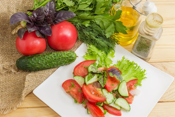 Salad with fresh tomatoes and cucumbers among ingredients, top view