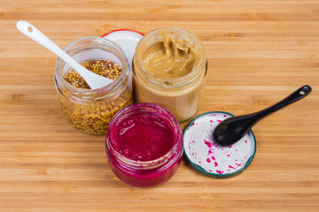 Traditional mustard, French mustard and horseradish sauce in small jars
