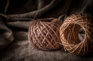 A coil of old, coarse, woolen thread. Vintage. A string of packing twine. The background is made of...