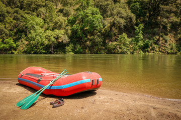 Inflatable boat adventure river raft ready for launch on the shore of a mountain stream