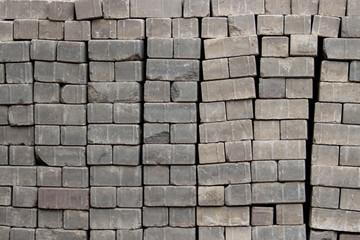 Bricks for paving stones stacked in stacks, background texture structure.