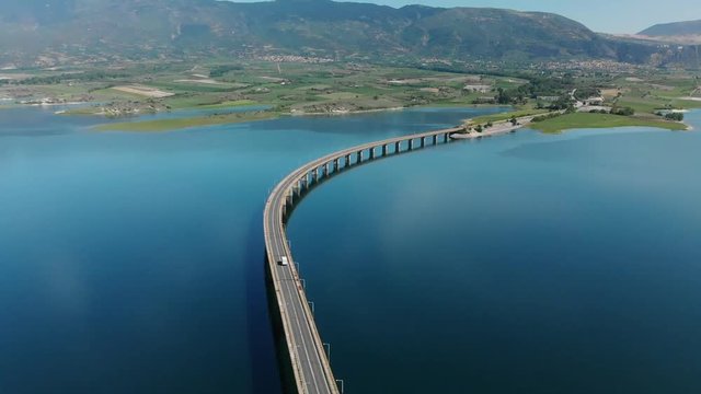 Techniti Limni Polifitou- White truck crossing the bridge on Polifitou Lake in Greece. Aerial.