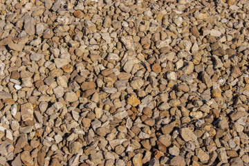 Yellow cobblestone gravel stones boulders pebbles texture background close-up