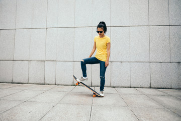 Woman skateboarder skateboarding at city