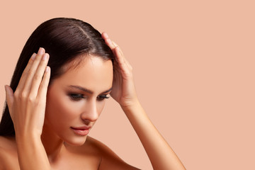  Young woman with hair loss problem on peach background. closeup. free space for advertising....
