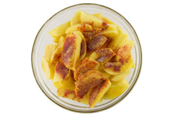 Raw potatoes with spices sliced in a transparent bowl. Ingredients for making delicious potatoes. Cooking potatoes in a rustic way.